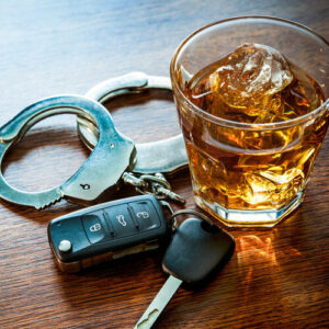 Whiskey with car keys and handcuffs concept for drinking and driving