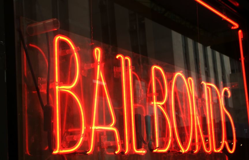 red neon bail bonds sign on urban storefront near Great Bend Kansas